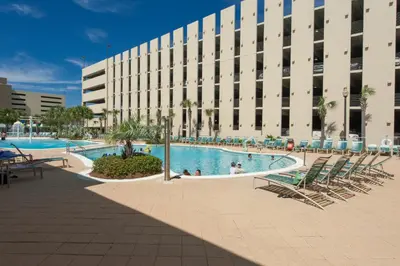 a large building with a swimming pool in front of a building at Brand New Throughout! Emerald Beach - Gulf Front! Sleeps 8! in Panama City Beach