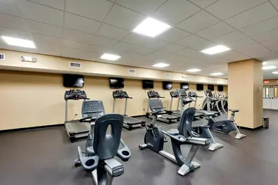 a gym with several rows of exercise bikes and treadmills at Brand New Throughout! Emerald Beach - Gulf Front! Sleeps 8! in Panama City Beach