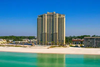 a tall building on a beach next to the water at 20th Floor Condo! Sleeps 8! Gulf Front Master Suite w/ Beautiful Gulf Views! in Panama City Beach