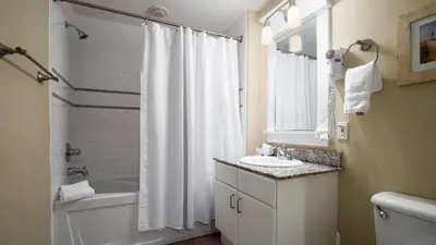 a bathroom with a white shower curtain and a sink at 20th Floor Condo! Sleeps 8! Gulf Front Master Suite w/ Beautiful Gulf Views! in Panama City Beach