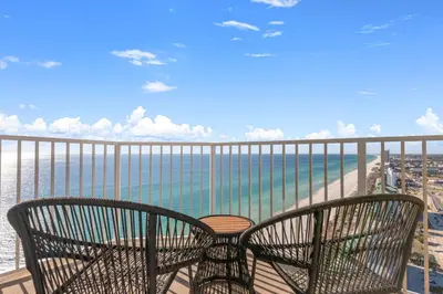 a balcony with two chairs and a view of the ocean at End Unit - Directly On The Gulf! Sleeps 6! Italian Luxury Furnishings! in Panama City Beach