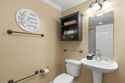 a bathroom with a toilet and a sink and a mirror at End Unit - Directly On The Gulf! Sleeps 6! Italian Luxury Furnishings! in Panama City Beach