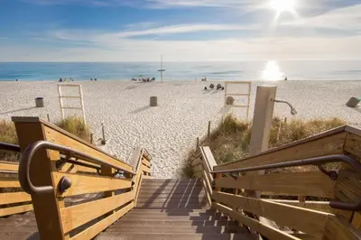 a stairway leading to a beach with people on it at End Unit - Directly On The Gulf! Sleeps 6! Italian Luxury Furnishings! in Panama City Beach
