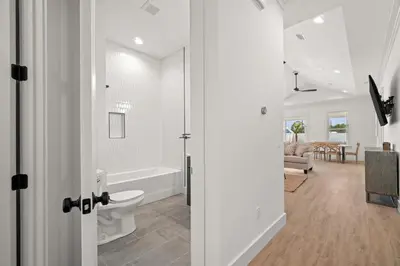 a bathroom with a tub and a toilet in a room at Brand New Home with In-ground Pool, Four Houses From Beautiful Laguna Beach in Panama City Beach