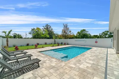 a swimming pool with chairs and a fence at Brand New Home with In-ground Pool, Four Houses From Beautiful Laguna Beach in Panama City Beach