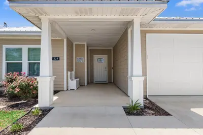 a front door of a house with a garage at Amazing New 3br/2ba Laguna Beach! / 6p GOLF CART: 2 mins to Beach/West PCB in Panama City Beach