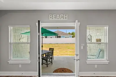 a dining room with a table and an umbrella at Amazing New 3br/2ba Laguna Beach! / 6p GOLF CART: 2 mins to Beach/West PCB in Panama City Beach