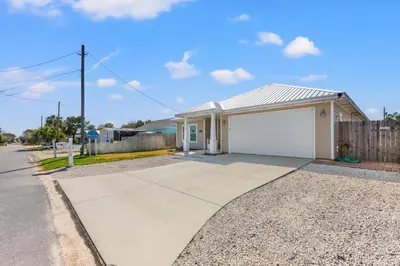a house with a white garage on a street at Amazing New 3br/2ba Laguna Beach! / 6p GOLF CART: 2 mins to Beach/West PCB in Panama City Beach