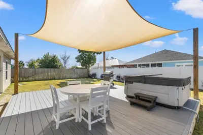 a patio with a grill and a table and chairs at Amazing New 3br/2ba Laguna Beach! / 6p GOLF CART: 2 mins to Beach/West PCB in Panama City Beach