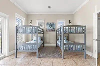 two bunk beds in a room with windows at 2 Gulf View Balconies! 3 Story Townhome With 4 Bedrooms, 4 Bathrooms! Sleeps12 in Panama City Beach