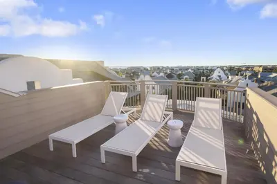 a balcony with white chairs on a roof at Private Pool, Gulf Views & Luxurious Features Throughout this Lovely Residence condo in Panama City Beach