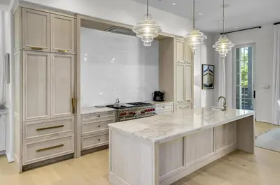 a large kitchen with white cabinets and a large island at Private Pool, Gulf Views & Luxurious Features Throughout this Lovely Residence condo in Panama City Beach