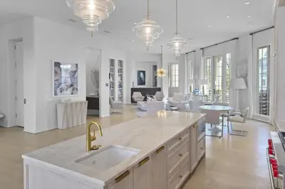 a kitchen and living room with white walls at Private Pool, Gulf Views & Luxurious Features Throughout this Lovely Residence condo in Panama City Beach