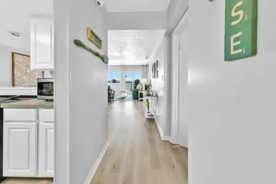 a kitchen with white cabinets and a long hallway at Pinnacle Port C1-502 in Panama City Beach