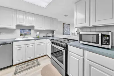 a kitchen with white cabinets and a microwave at Pinnacle Port C1-502 in Panama City Beach