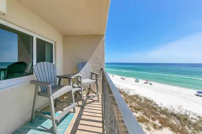 a balcony with two chairs and a view of the beach at Pinnacle Port C1-502 in Panama City Beach