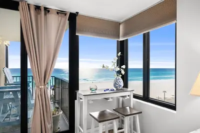 a room with a balcony with a view of the ocean at Newly Renovated Beachfront Condo! Free Beach Chair Service! by Dolce Vita Getaways PCB in Panama City Beach