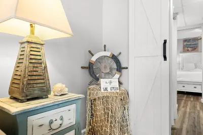 a room with a table with a clock on it at Newly Renovated Beachfront Condo! Free Beach Chair Service! by Dolce Vita Getaways PCB in Panama City Beach