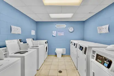 a blue room with washing machines and a toilet at Newly Renovated Beachfront Condo! Free Beach Chair Service! by Dolce Vita Getaways PCB in Panama City Beach