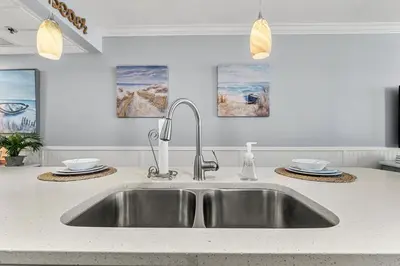 a kitchen counter with a sink in a kitchen at Newly Renovated Beachfront Condo! Free Beach Chair Service! by Dolce Vita Getaways PCB in Panama City Beach