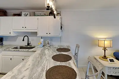 a kitchen with a table and a sink at Wendwood #E2 in Panama City Beach