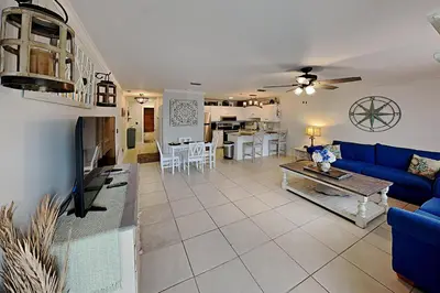 a living room with a blue couch and a table at Wendwood #E2 in Panama City Beach