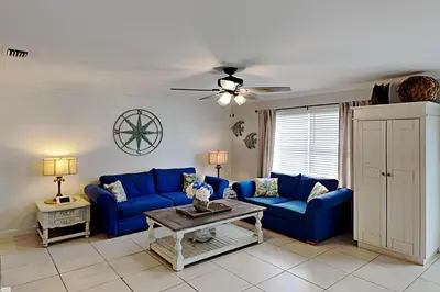 a living room with blue couches and a table at Wendwood #E2 in Panama City Beach