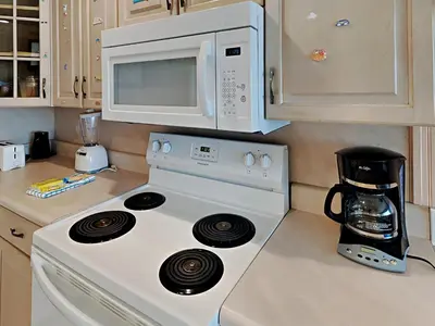 a kitchen with a white stove top oven and a microwave at Continental 319-320 in Panama City Beach