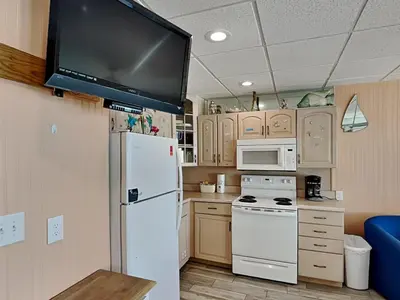 a kitchen with a refrigerator and a tv on the wall at Continental 319-320 in Panama City Beach