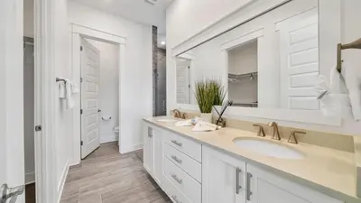 a white bathroom with two sinks and a mirror at Current Affairs Brand New 2 BR Townhome in Prominence Golf Cart Included in Inlet Beach