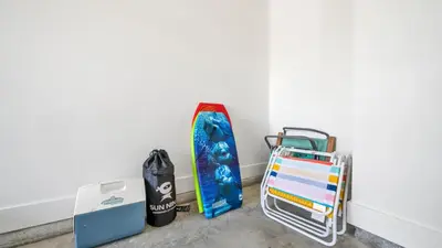 a snowboard leaned against a wall next to a cart at Current Affairs Brand New 2 BR Townhome in Prominence Golf Cart Included in Inlet Beach