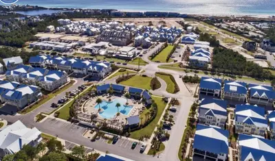 an aerial view of a resort with a pool and buildings at Current Affairs Brand New 2 BR Townhome in Prominence Golf Cart Included in Inlet Beach