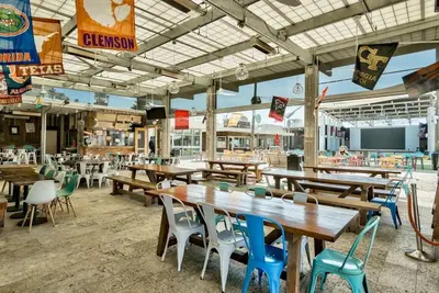 an empty restaurant with wooden tables and chairs at Current Affairs Brand New 2 BR Townhome in Prominence Golf Cart Included in Inlet Beach