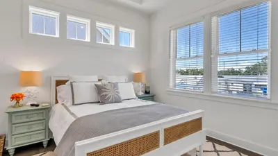 a white bedroom with a bed and windows at Current Affairs Brand New 2 BR Townhome in Prominence Golf Cart Included in Inlet Beach