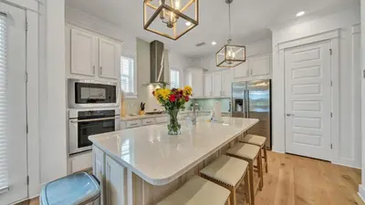a kitchen with a large island with a vase of flowers at Aint Nothin Wrong With Getting Your Sun Daze On in Panama City Beach