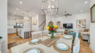 a kitchen and living room with a table and chairs at Aint Nothin Wrong With Getting Your Sun Daze On in Panama City Beach