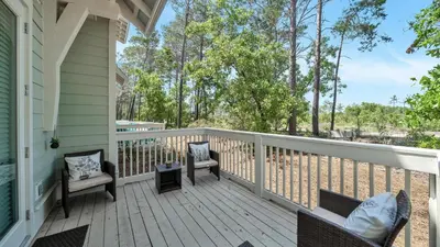 a porch with chairs and tables on a house at Aint Nothin Wrong With Getting Your Sun Daze On in Panama City Beach