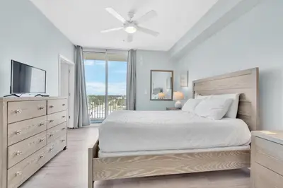 a bedroom with a large bed and a television at Aqua Resort 811 in Panama City Beach