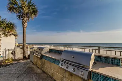 a bench on a wall next to the beach at Aqua Resort 811 in Panama City Beach