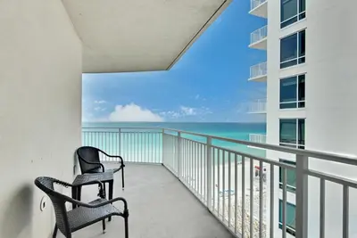 two chairs on a balcony with a view of the ocean at Aqua Resort 811 in Panama City Beach