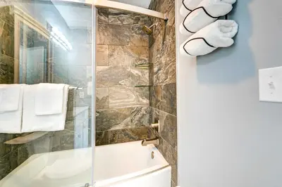 a bathroom with a shower and a toilet and towels at Walkable Panama City Beach Condo with Pool Access! in Panama City Beach