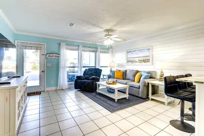 a living room with a couch and a table at Walkable Panama City Beach Condo with Pool Access! in Panama City Beach