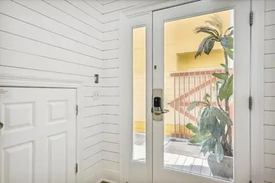 a door to a house with a plant at Just Beachy - 5 Bedroom 5 Bathroom Beach Front Home! Sleeps 20 home in Panama City Beach