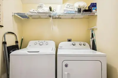 a laundry room with two washing machines and a shelf at Just Beachy - 5 Bedroom 5 Bathroom Beach Front Home! Sleeps 20 home in Panama City Beach