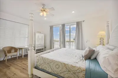 a bedroom with a bed and a table and a window at Just Beachy - 5 Bedroom 5 Bathroom Beach Front Home! Sleeps 20 home in Panama City Beach