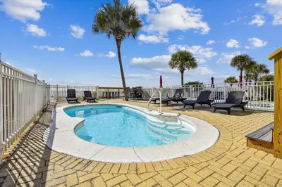 a small swimming pool with chairs and a fence at Just Beachy - 5 Bedroom 5 Bathroom Beach Front Home! Sleeps 20 home in Panama City Beach