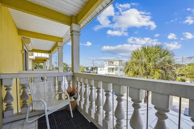 a balcony with a white railing and palm trees at Just Beachy - 5 Bedroom 5 Bathroom Beach Front Home! Sleeps 20 home in Panama City Beach