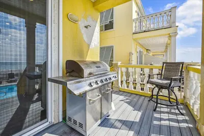 a balcony with a grill on a house at Just Beachy - 5 Bedroom 5 Bathroom Beach Front Home! Sleeps 20 home in Panama City Beach