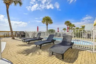 a group of chairs sitting next to a swimming pool at Just Beachy - 5 Bedroom 5 Bathroom Beach Front Home! Sleeps 20 home in Panama City Beach