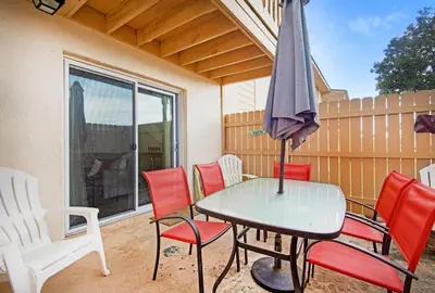 a table and chairs with an umbrella on a patio at Horizon South 8B2- Sunshine Gardens in Panama City Beach